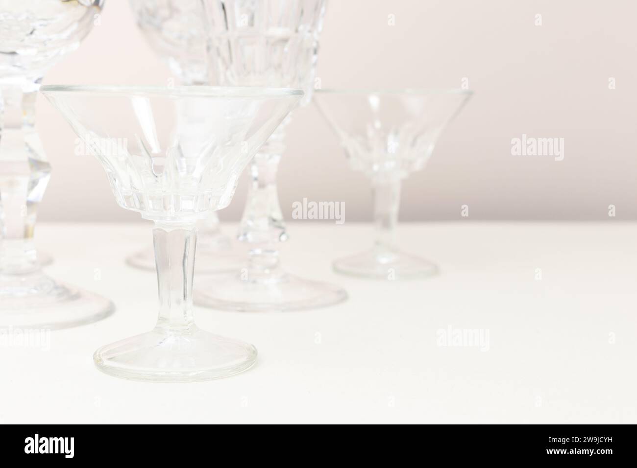 Verres en cristal devant fond beige. Composition minimale. Banque D'Images