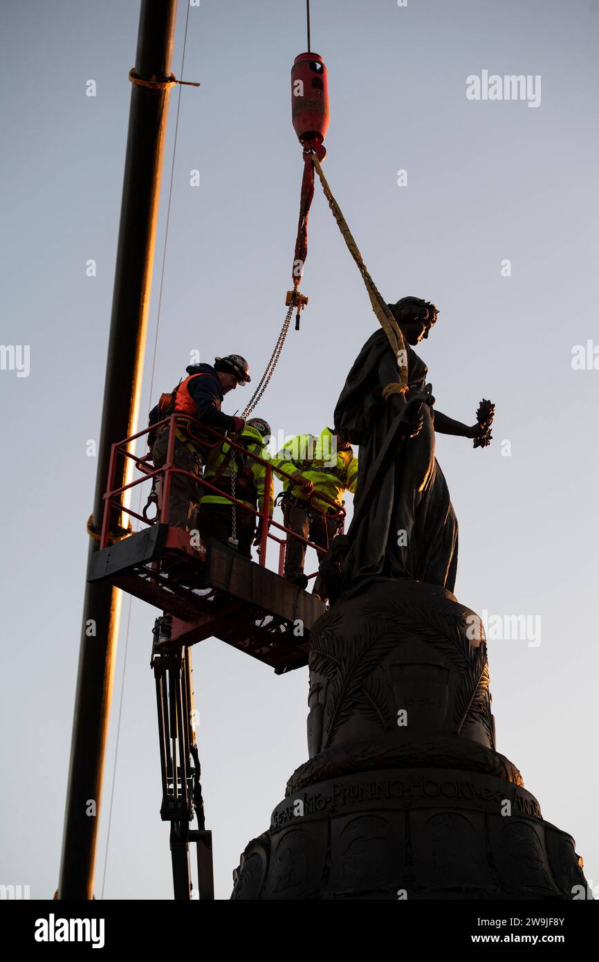 Arlington (États-Unis d ' Amérique). 20 décembre 2023. Les ouvriers attachent des sangles à la statue de bronze sur le Mémorial confédéré dans la section 16 du cimetière national d'Arlington avant d'être enlevés par grue, le 20 décembre 2023 à Arlington, en Virginie. Le mémorial honorant les membres des États confédérés d'Amérique est déplacé dans le parc historique d'État du champ de bataille de New Market. Crédit : Elizabeth Fraser/États-Unis Army/Alamy Live News Banque D'Images