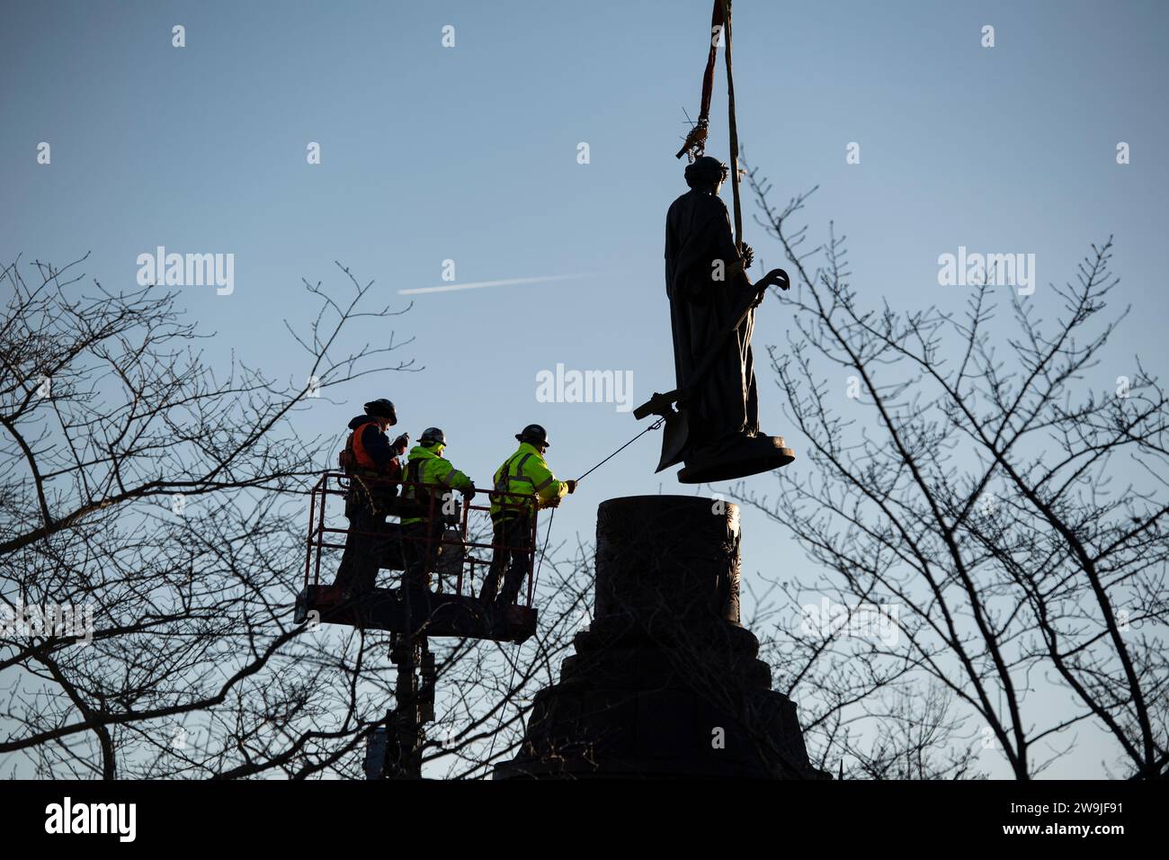 Arlington (États-Unis d ' Amérique). 20 décembre 2023. Les ouvriers guident la statue de bronze sur le Mémorial confédéré dans la section 16 du cimetière national d'Arlington lors de son enlèvement par grue, le 20 décembre 2023 à Arlington, en Virginie. Le mémorial honorant les membres des États confédérés d'Amérique est déplacé dans le parc historique d'État du champ de bataille de New Market. Crédit : Elizabeth Fraser/États-Unis Army/Alamy Live News Banque D'Images