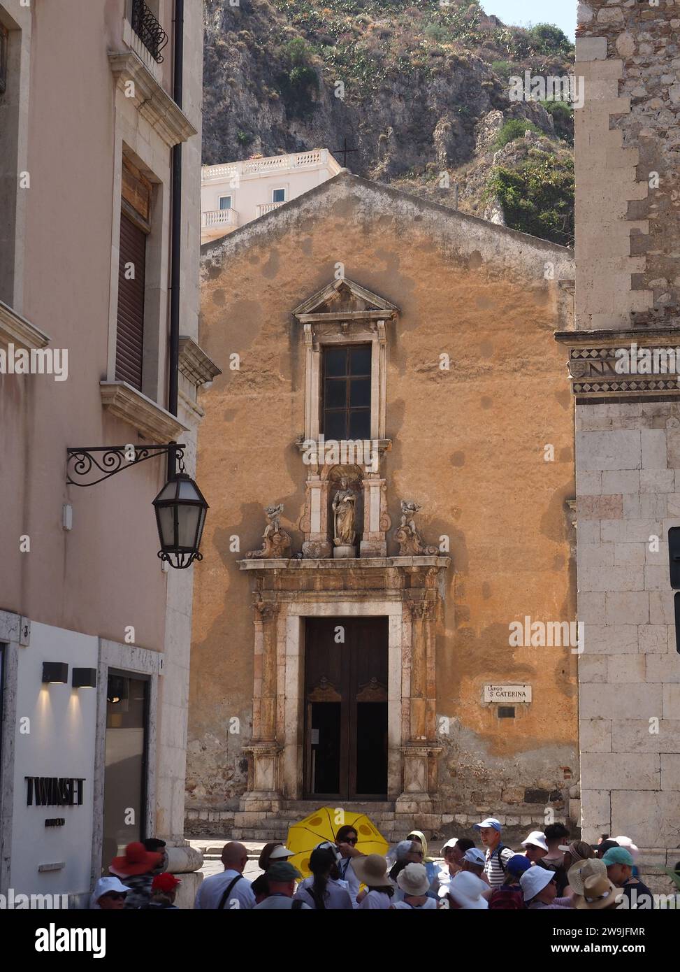La rue historique et une église de Taormina Sicile avec des touristes et un guide Banque D'Images