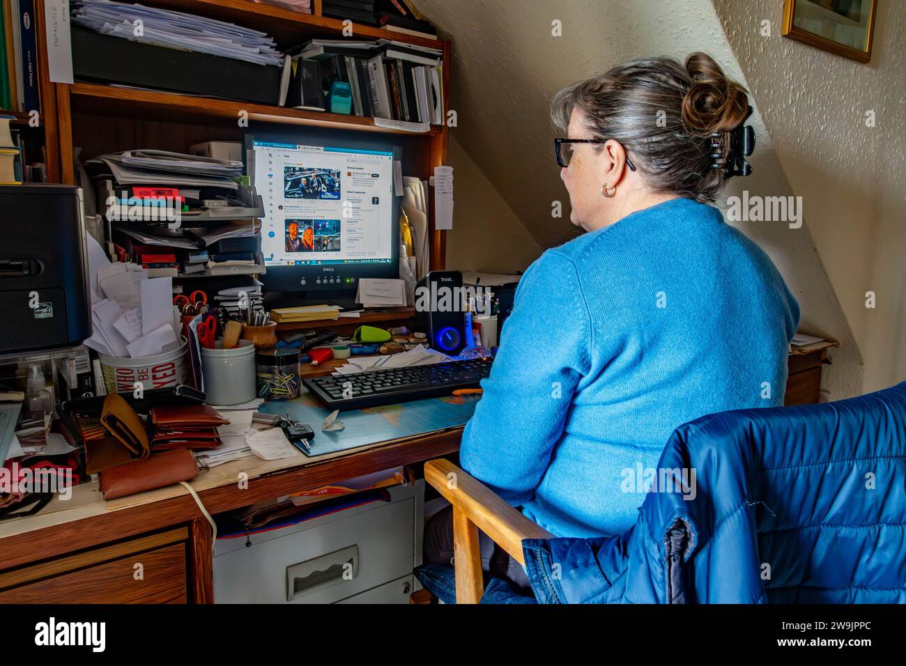 Une femme est assise et utilise un ordinateur dans le bureau sous les escaliers Banque D'Images