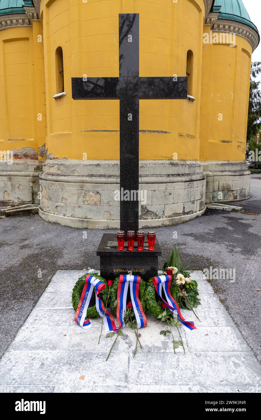 Croix près de la chapelle orthodoxe jaune de Saint-Pierre et Paul sur le cimetière Mirogoj à Zagreb avec des couronnes avec des rubans russes blanc-bleu-rouge ; dans la mémoire éternelle Banque D'Images