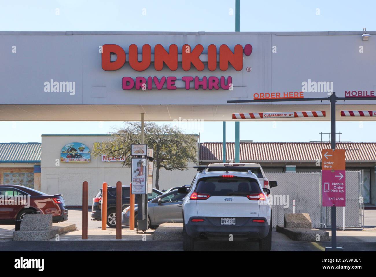 Le drive-in et la signalisation d'un emplacement Dunkin' Donuts à San Antonio, Texas, États-Unis, le 28 décembre 2023. Fondée en 1948, Dunkin' Donuts compte actuellement environ 12 900 sites dans 42 pays. En 2020, la société a été rachetée par inspire Brands. Inspire Brands LLC est propriétaire et franchiseur des chaînes de restaurants Arby's, Buffalo Wild Wings, Sonic Drive-In, Jimmy John's, Mister Donut et Baskin-Robbins. Inspire Brands appartient à Roark Capital Group. Roark Capital est une société américaine de capital-investissement avec environ 37 milliards d'actifs sous gestion. La société de capital-investissement porte le nom de H. Banque D'Images