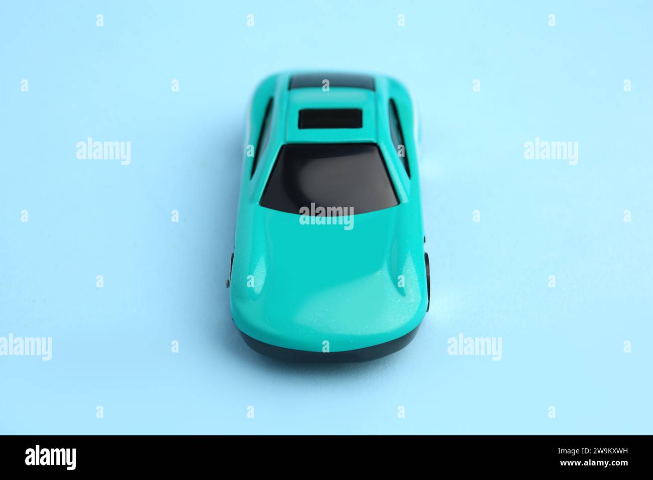 Une voiture lumineuse sur fond bleu clair. Jouet pour enfants Banque D'Images