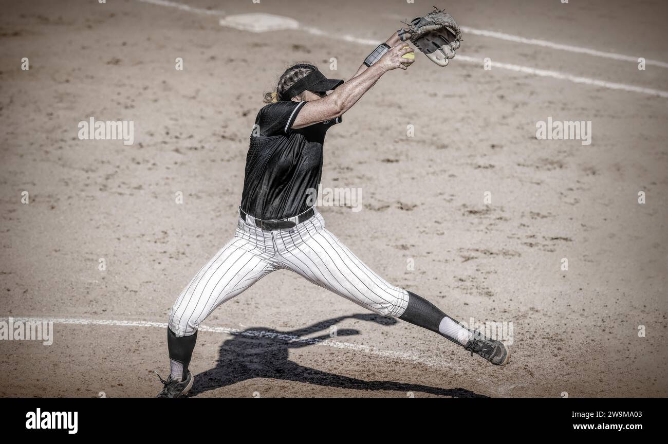 Un joueur de softball féminin est en Full Windup pitching Antique Grainy Monochrome Banque D'Images