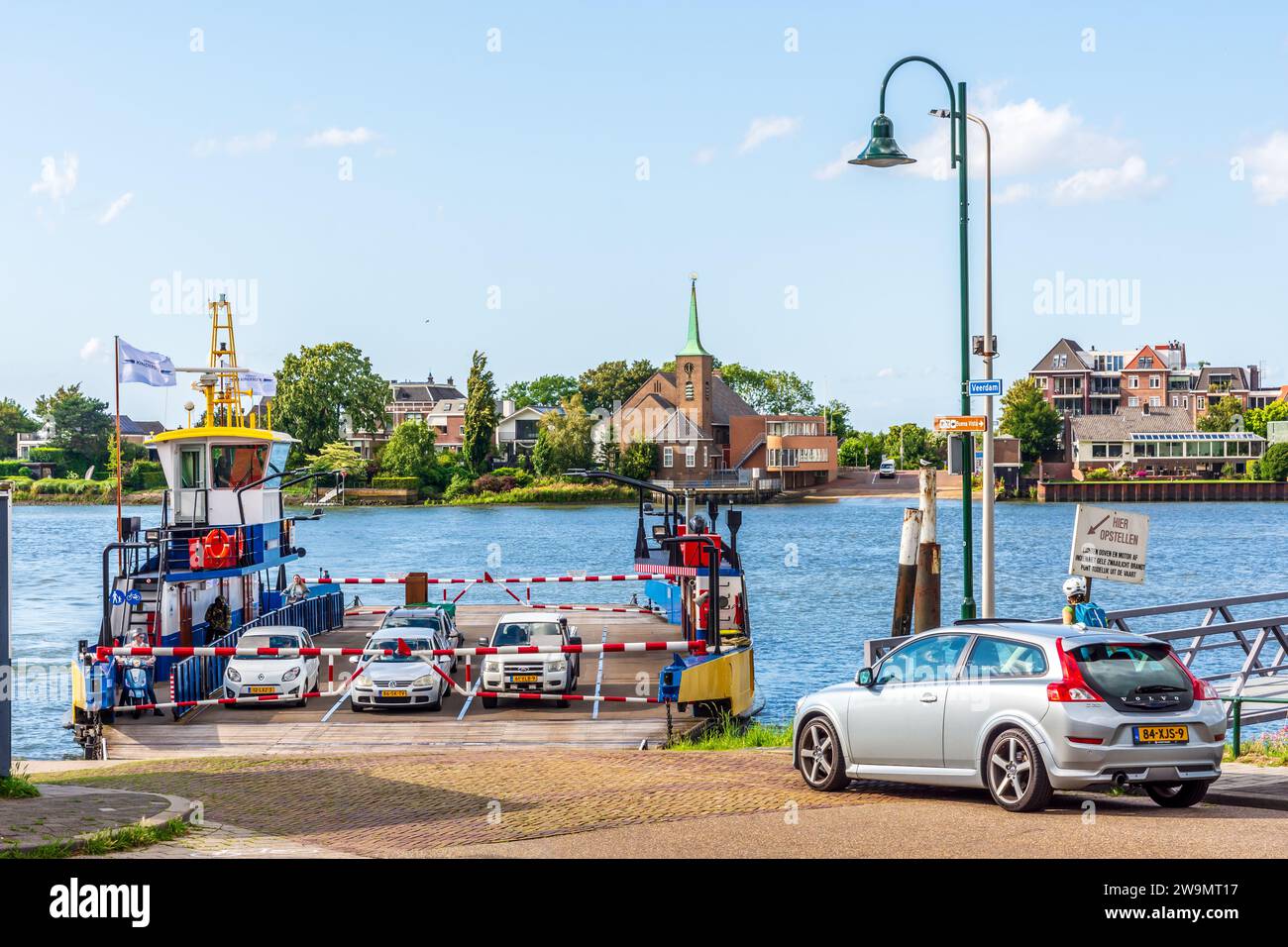 Le ferry en provenance de Krimpen aan de Lek accoste à l'embarcadère de Kinderdijk, aux pays-Bas, avec des passagers en voiture, scooter et vélo. Banque D'Images