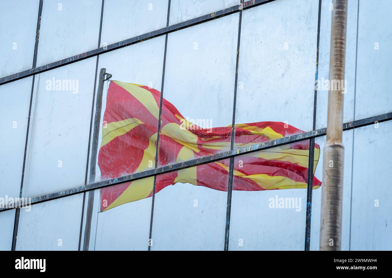 Drapeau macédonien. Réflexion ondulante, dans les cadres de fenêtres en verre. Motif et texture. Banque D'Images