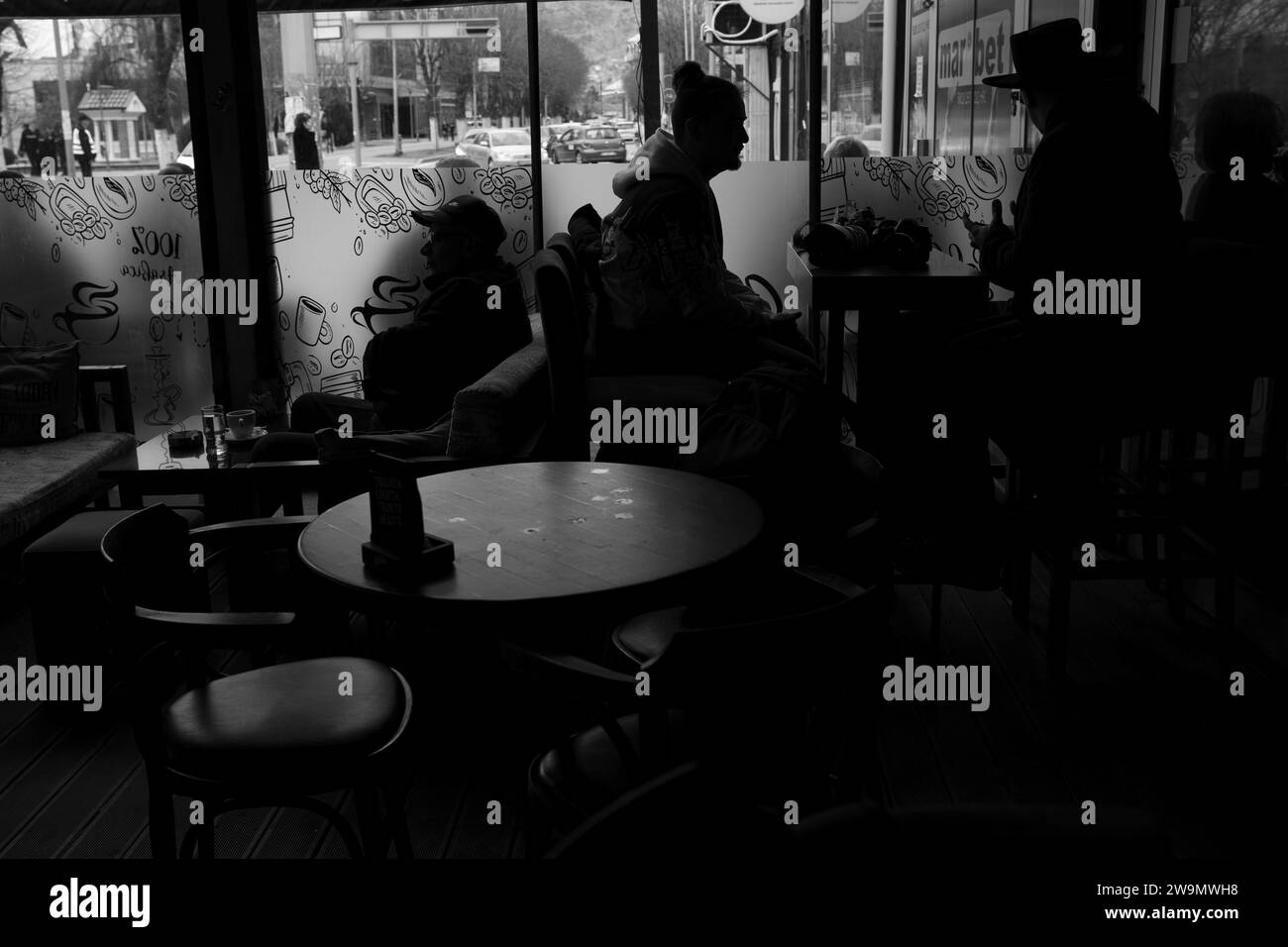 Les gens au café-bar, discutant. Mistery place. Habitudes quotidiennes. Noir et blanc, monochrome.tables et chaises. Silhouettes. 2.26.2023 Banque D'Images