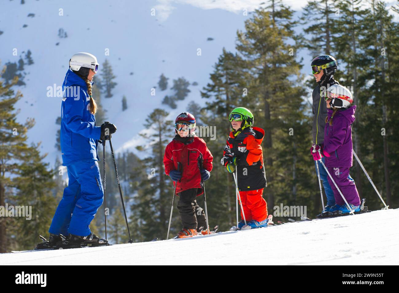 Un groupe de jeunes skieurs se réunissent autour de leur moniteur de ski tout en prenant une leçon à Kirkwood Mountain Resort à Kirkwood, en Californie. Banque D'Images