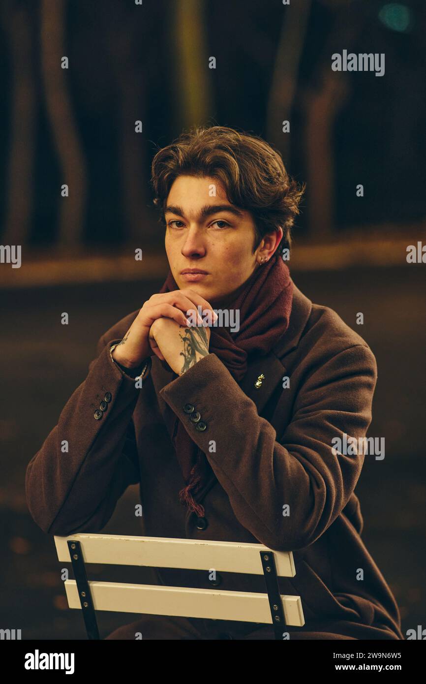 portrait jeune homme avec les mains sur le menton à l'extérieur dans la ville la nuit Banque D'Images
