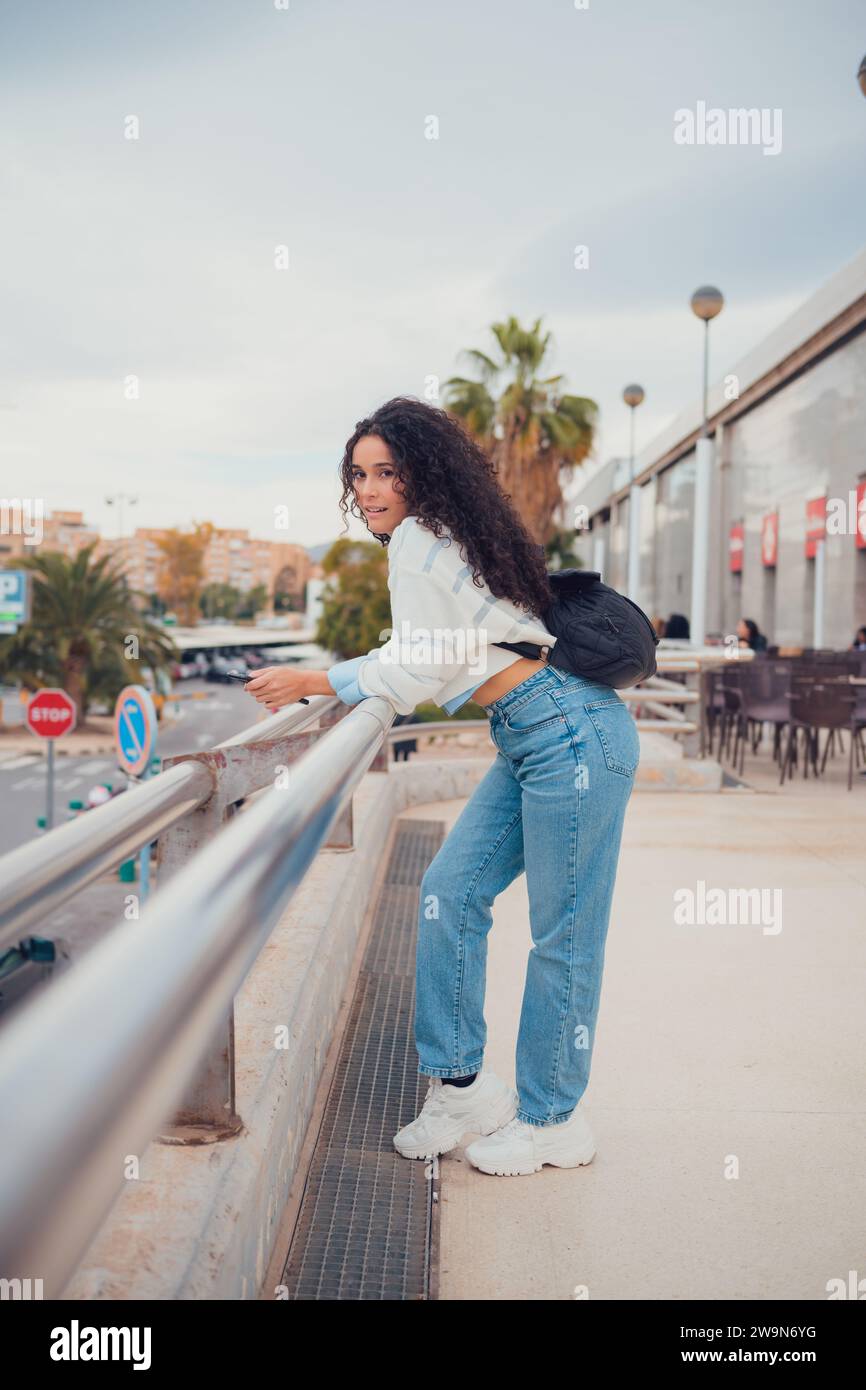 Femme sud-américaine aux cheveux bouclés souriant et regardant la caméra Banque D'Images