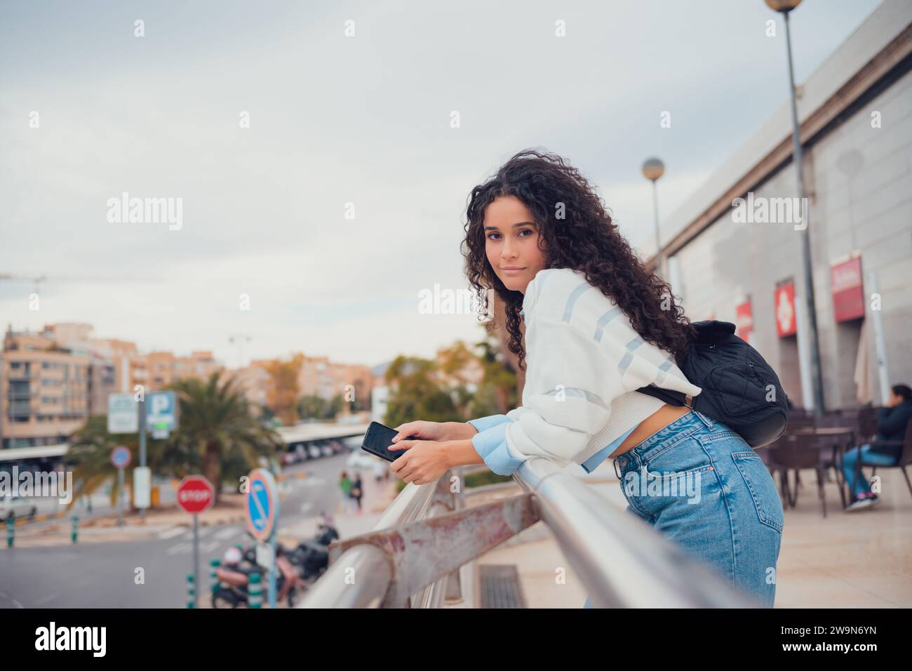 Femme sud-américaine aux cheveux bouclés souriant et regardant la caméra Banque D'Images