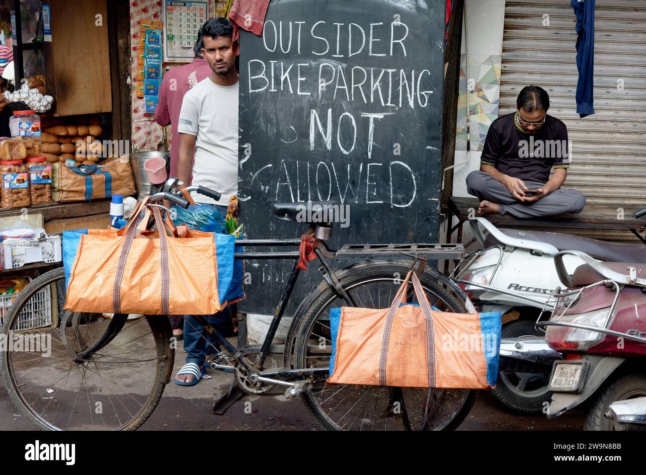 Dans une ruelle étroite à Dongri, Mumbai, en Inde, un panneau d’affichage interdit aux non-résidents de garer leurs vélos, l’espace pour les voitures étant de toute façon inexistant Banque D'Images