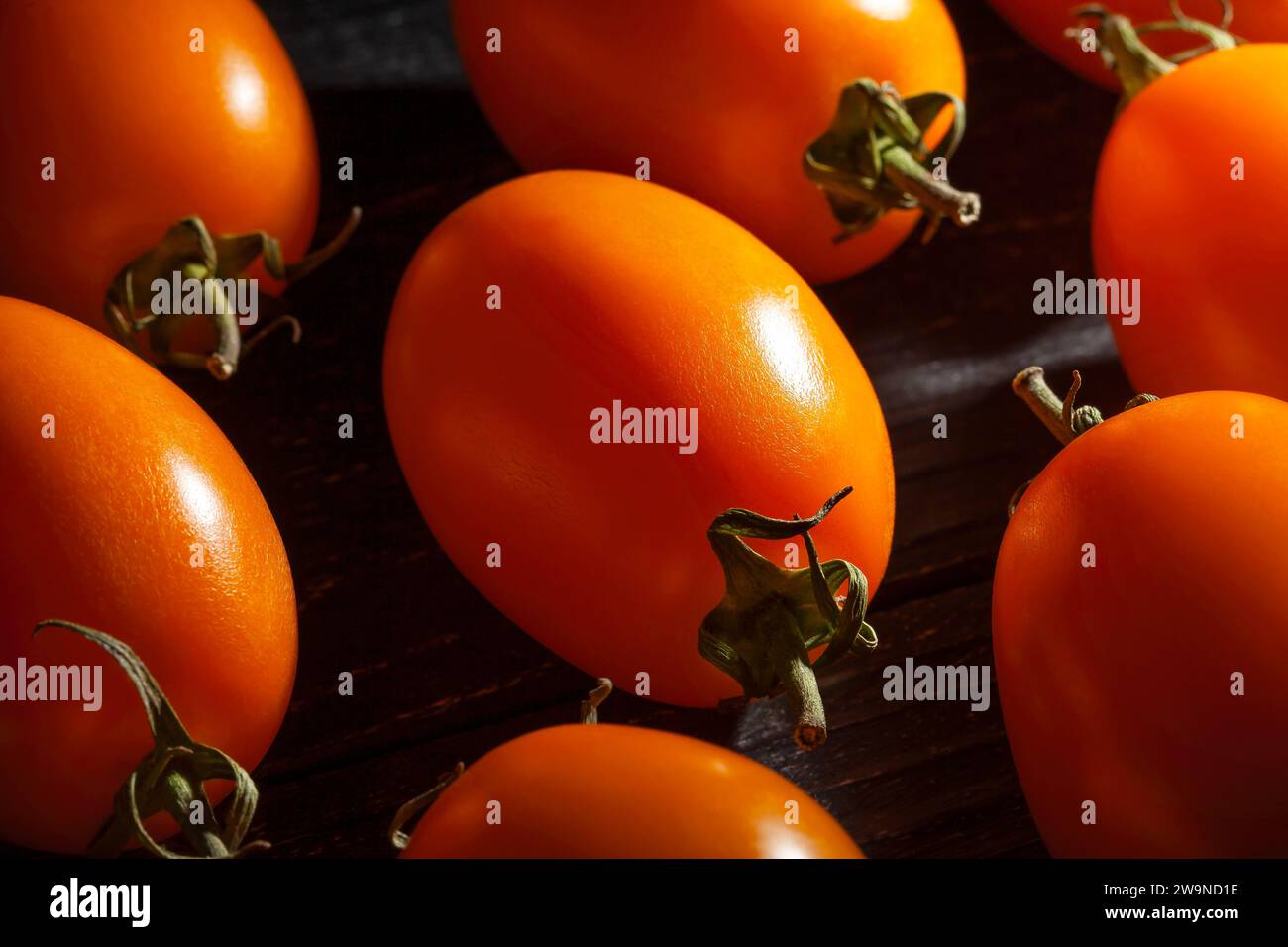 tomate prune orange sur fond de bois Banque D'Images