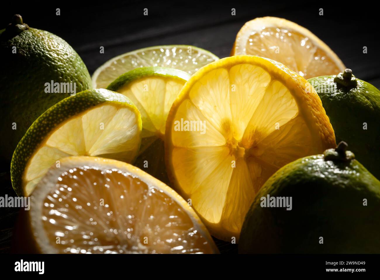 limes de citron tranchées se mélangent sur fond noir Banque D'Images