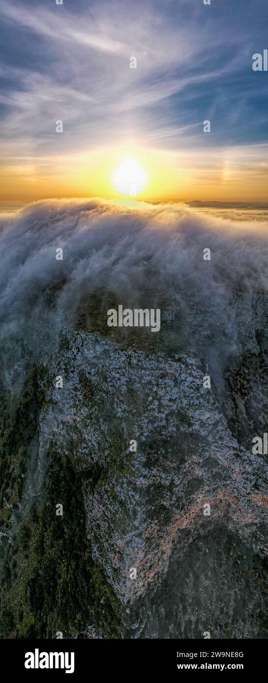 Sicile 2023. Nuages qui grimpent sur le mont Santa Caterina sur l'île de Favignana. Derrière nous voyons le soleil à l'aube. Juillet 2023 Trapani, Italie Banque D'Images