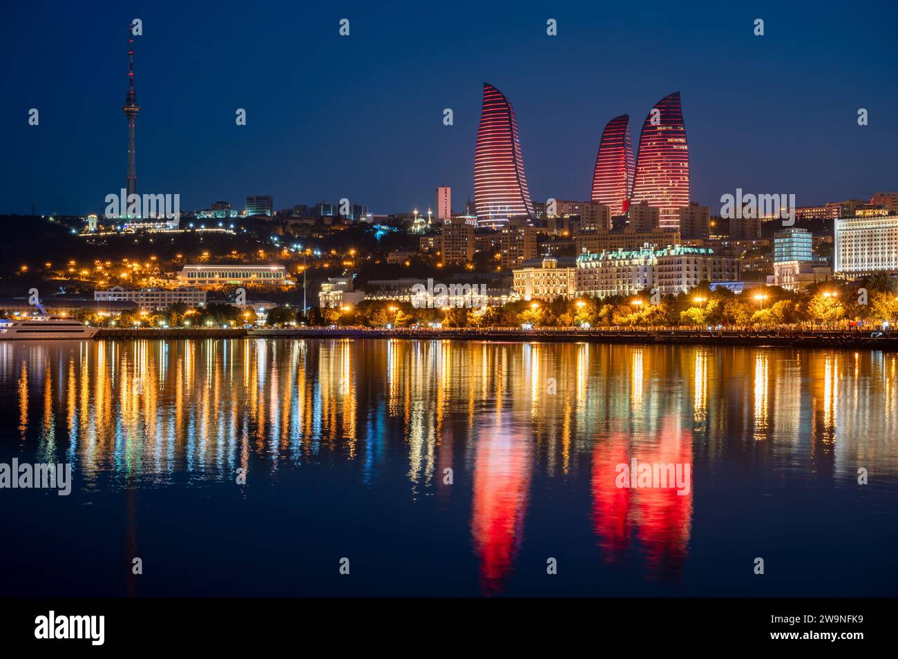 Vue de nuit sur la ligne d'horizon de Bakou, capitale de l'Azerbaïdjan avec reflet des tours de flamme dans les eaux de la mer Caspienne. Banque D'Images