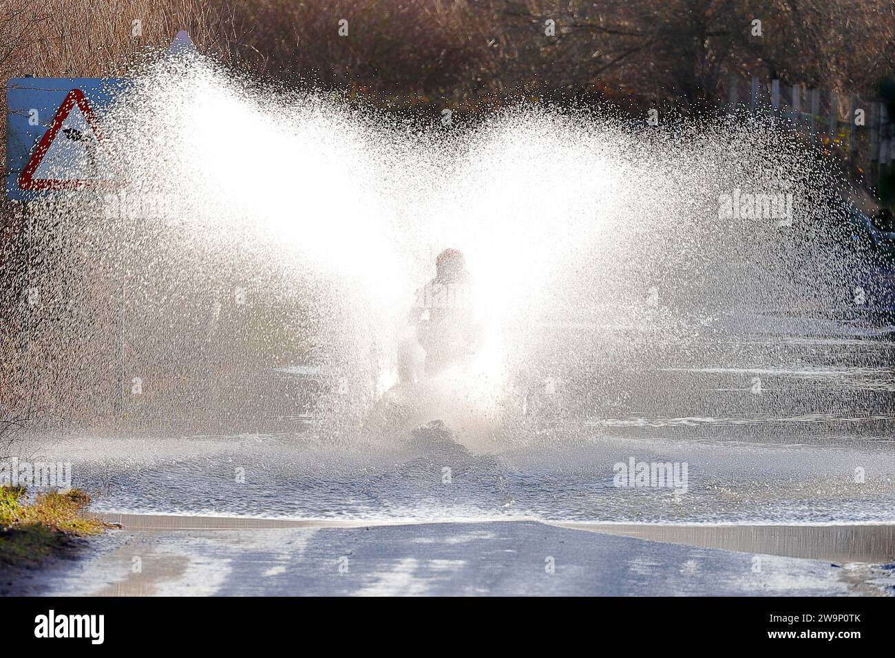 Un motocycliste vu rouler à travers les eaux d'inondation sur Newton Lane, Fairburn, North Yorkshire, Royaume-Uni Banque D'Images