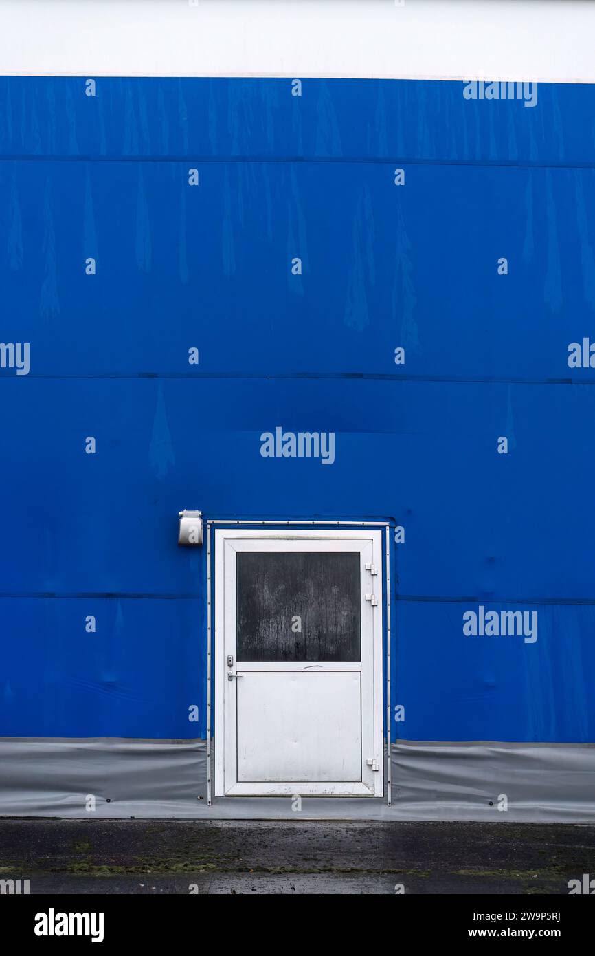 Porte en métal sur le mur bleu de l'arène sportive. Banque D'Images