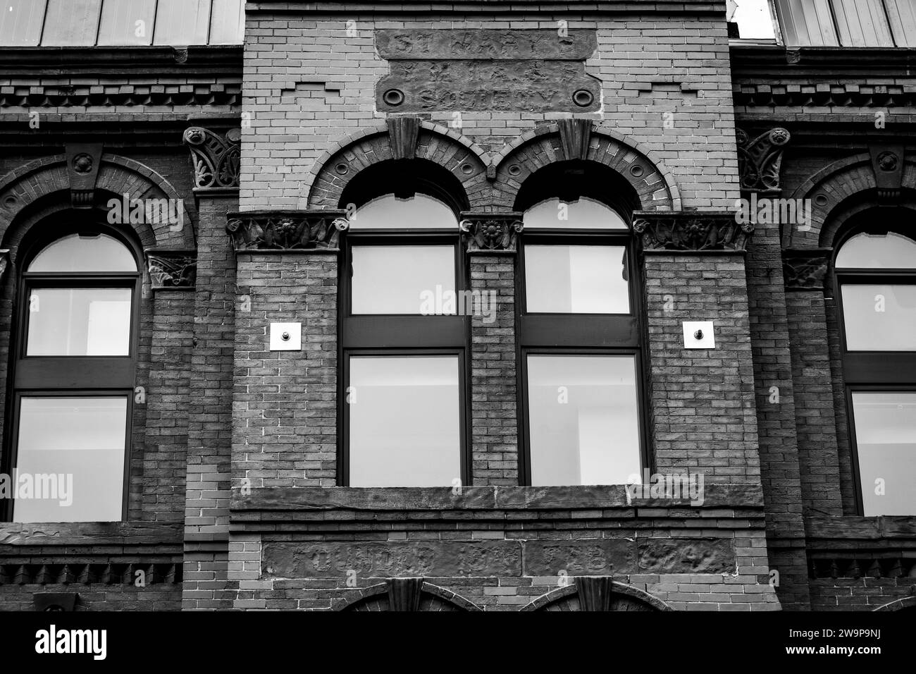 Fenêtres cintrées à l'extérieur d'un bâtiment en briques. Banque D'Images