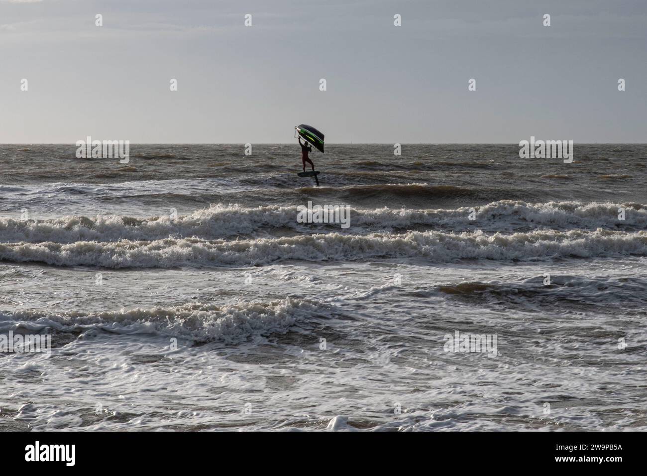 Silhouette d'une personne wingfoiling dans la mer Banque D'Images