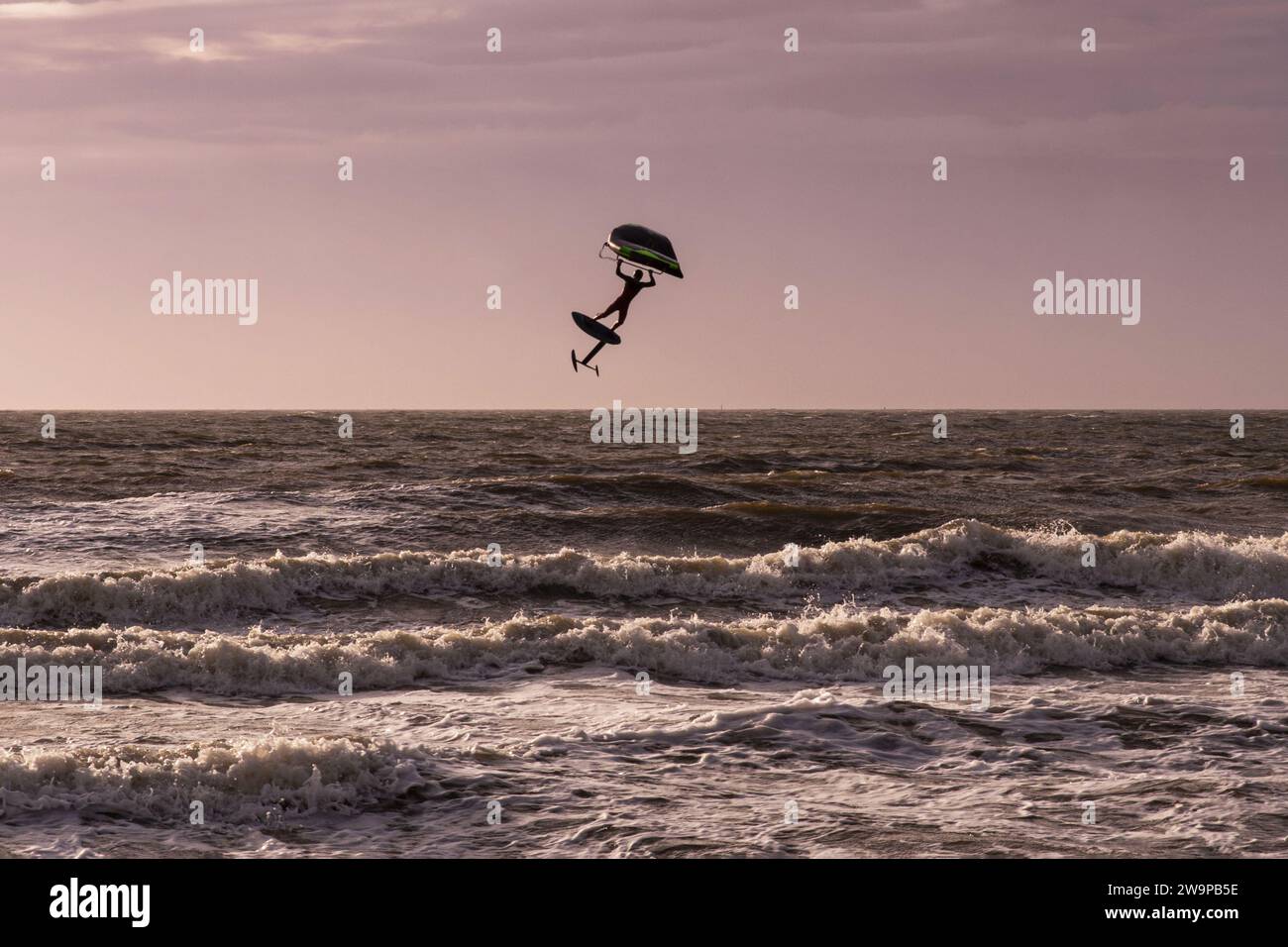 Silhouette d'une personne wingfoiling dans la mer Banque D'Images