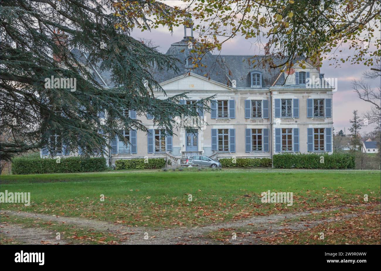 Grande maison française avec une petite voiture garée à l'extérieur et volets peints en bleu Banque D'Images