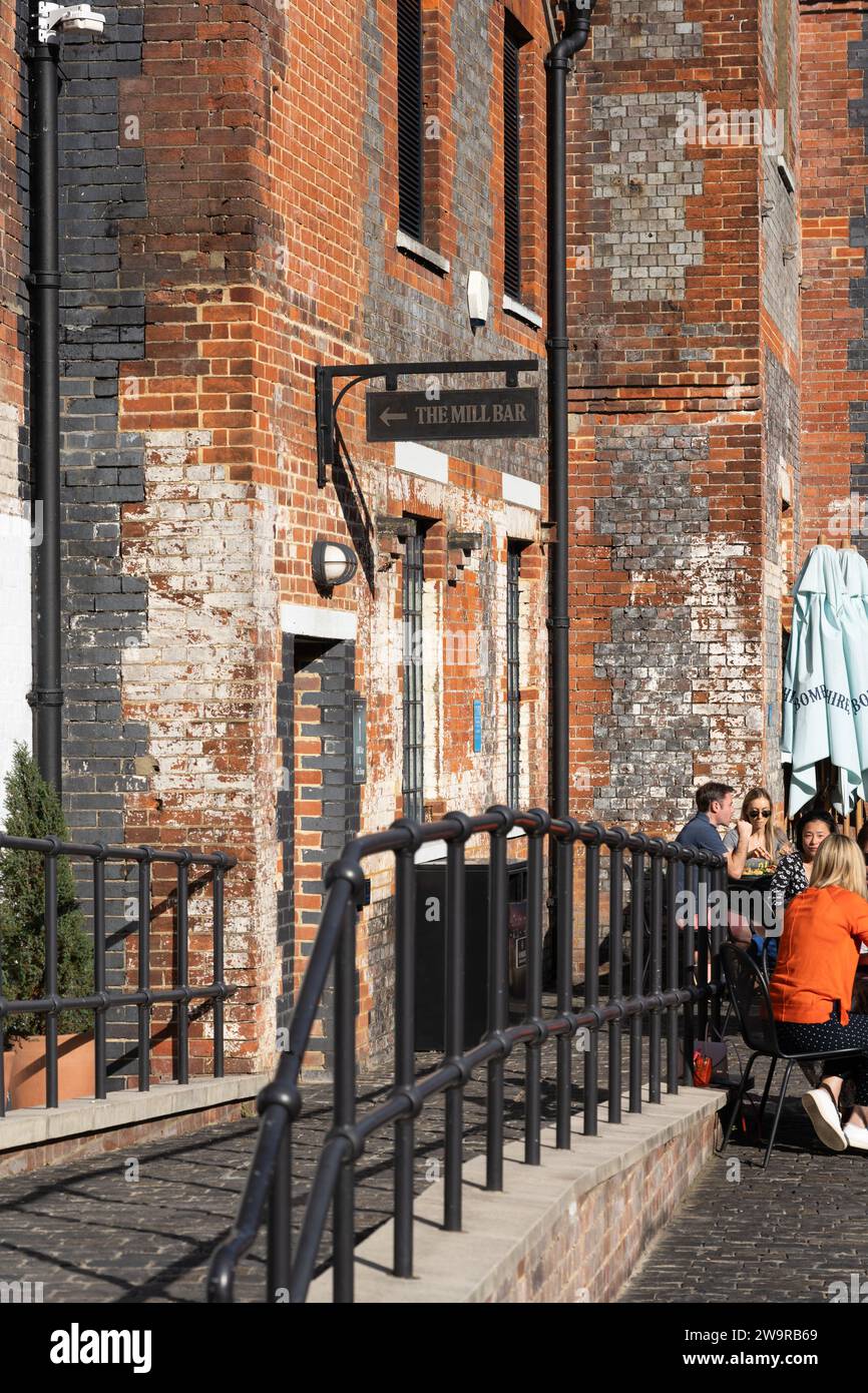 Les visiteurs de la distillerie Bombay Sapphire mangent et boivent devant le Mill café de l'historique Laverstoke Mill, Whitchurch, Hampshire, Angleterre Banque D'Images