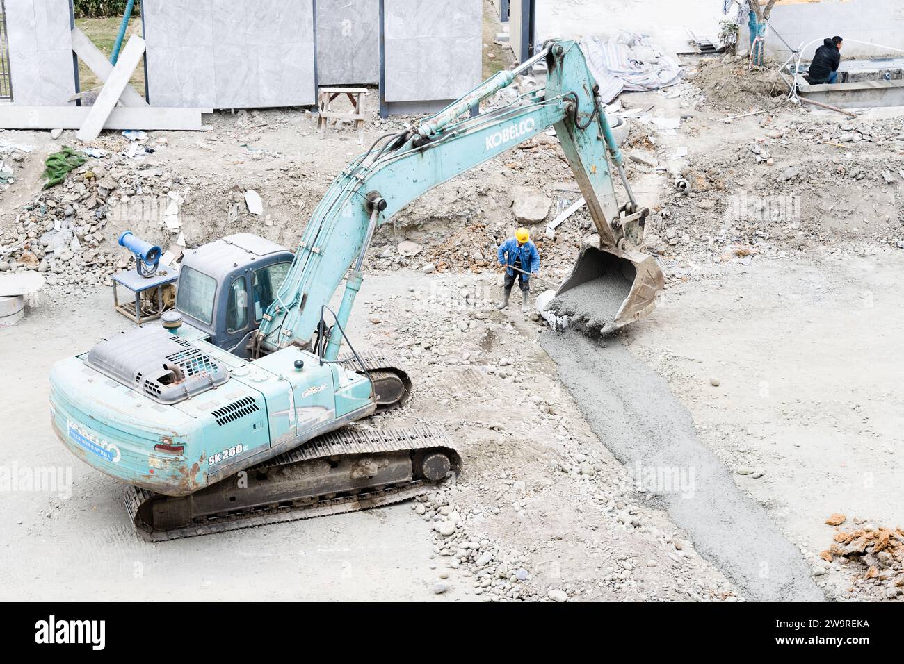 Les tuyaux sont arrosés avec des camions de ciment et des camions excavateurs Banque D'Images