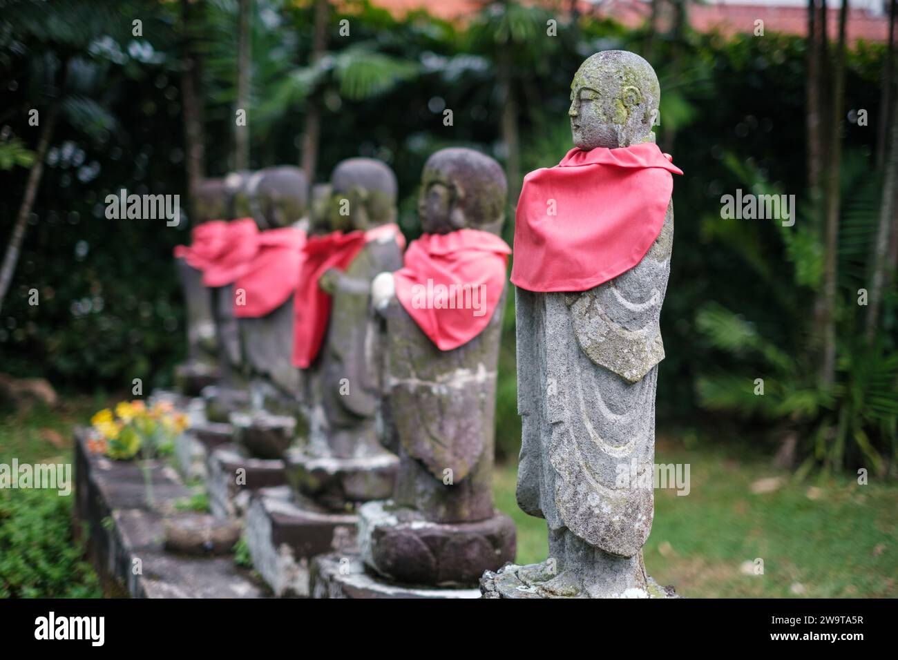 Singapour - juillet 9 2023 : rangée de statues de Mini moine de pierre avec écharpes rouges Banque D'Images