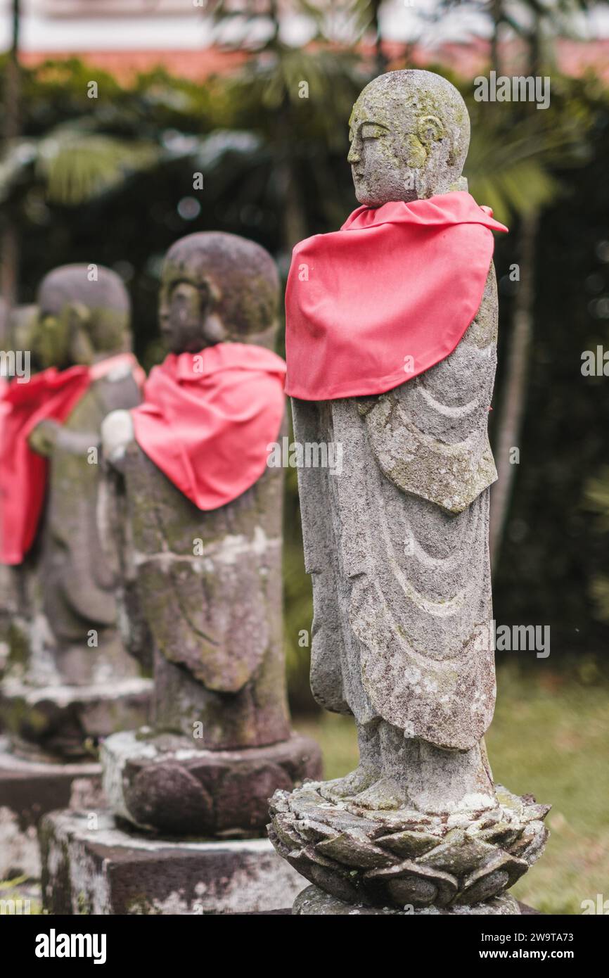 Singapour - juillet 9 2023 : rangée de statues de Mini moine de pierre avec écharpes rouges Banque D'Images