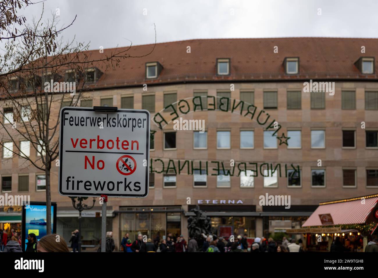 Zweisprachiges Hinweisschild für das Feuerwerksverbot in der Nürnberger Altstadt während der Silvesternacht in Deutsch und Englisch und dem Symbol mit durchgestricheneer Rakete und Böller.hier in der Spitalgasse im Übergang zum Hans-Sachs-Platz. *** Panneau bilingue pour l'interdiction des feux d'artifice dans la vieille ville de Nurembbergs pendant la Saint-Sylvestre en allemand et en anglais et le symbole avec une fusée barrée et des pétards ici à Spitalgasse à la transition vers Hans Sachs Platz 20231230-6V2A7018 Banque D'Images