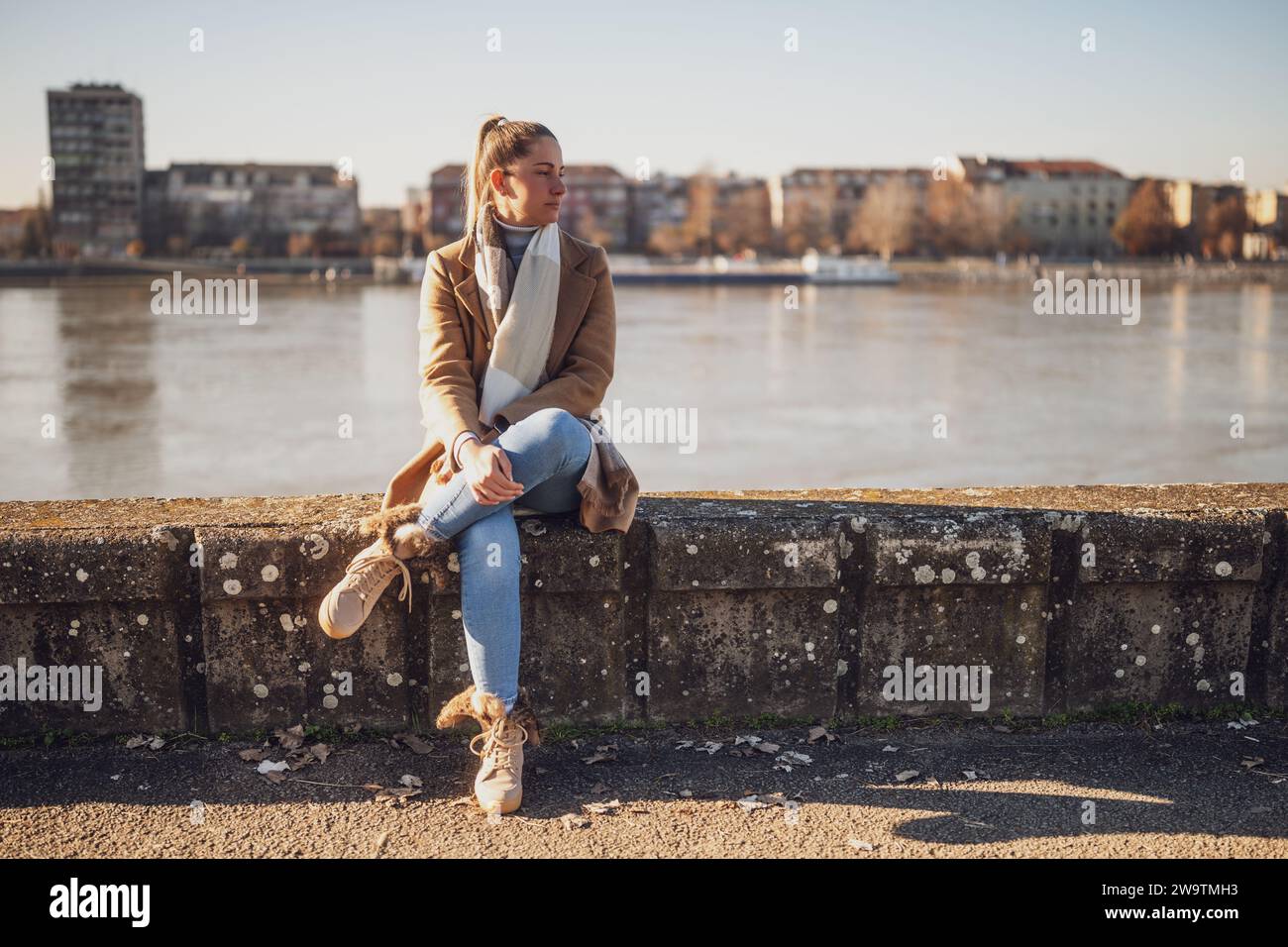 Femme triste assise au bord de la rivière. Banque D'Images