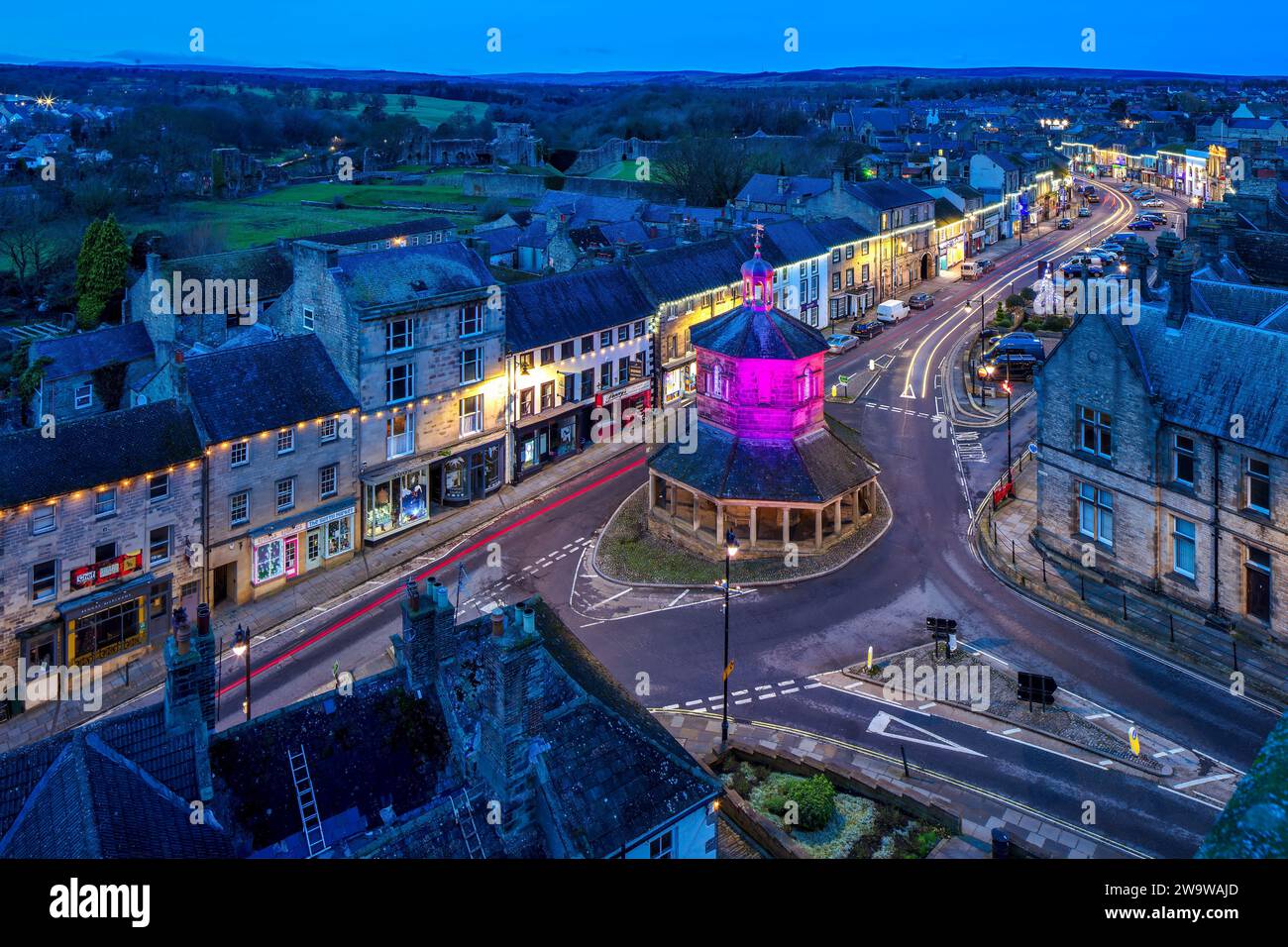 Vue au crépuscule du château de Barnard au moment de Noël avec des lumières et décorations de Noël donnant sur la Market Cross et le long de la rue principale A67 Banque D'Images