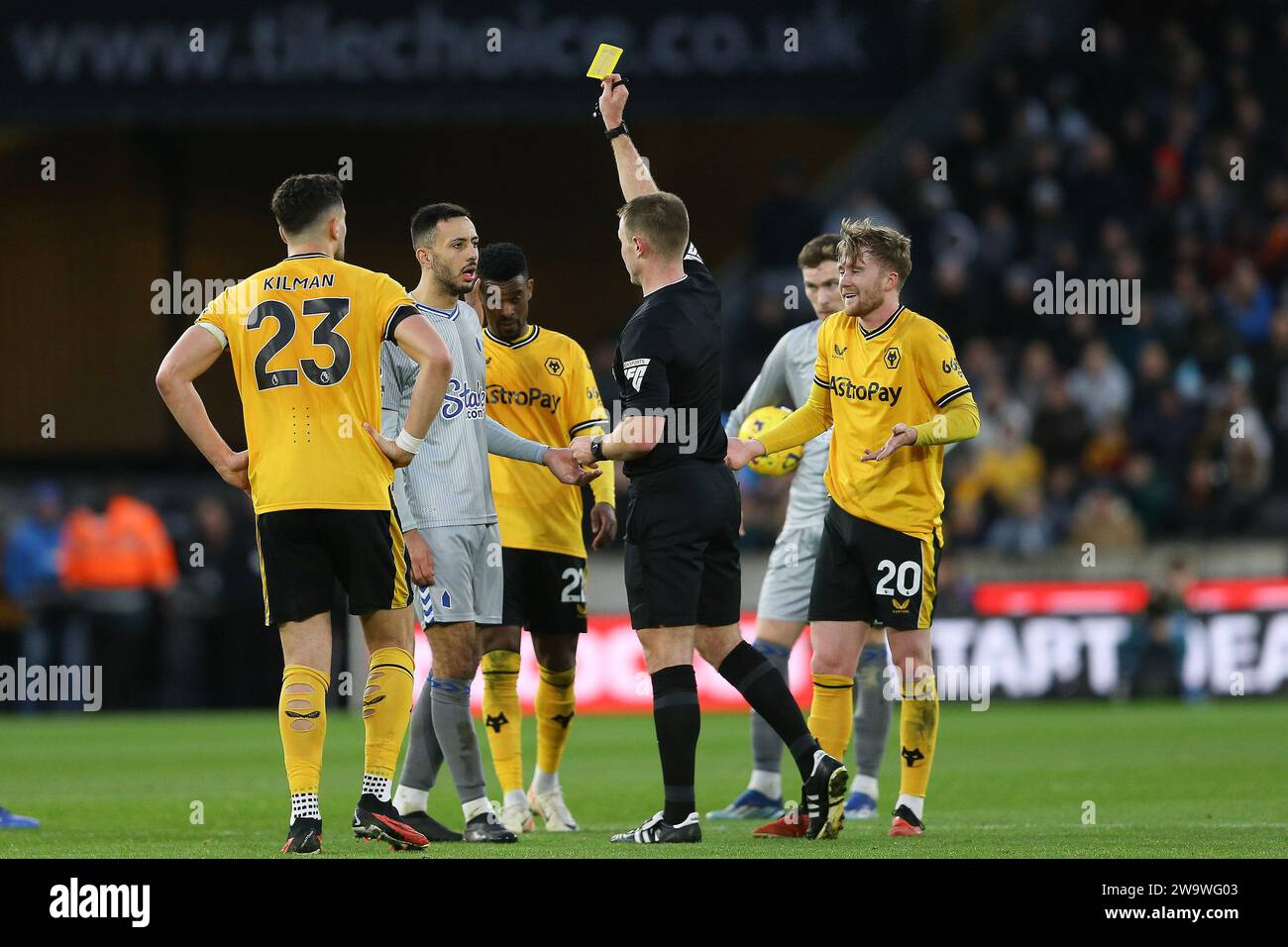 Wolverhampton, Royaume-Uni. 30 décembre 2023. Dwight McNeil d'Everton (à gauche) et Tommy Doyle de Wolverhampton Wanderers (20) sont tous les deux inscrits car ils reçoivent un carton jaune de l'arbitre Tom Bramall. Match de Premier League, Wolverhampton Wanderers contre Everton au Molineux Stadium à Wolverhampton, Angleterre, le samedi 30 décembre 2023. Cette image ne peut être utilisée qu'à des fins éditoriales. Usage éditorial uniquement, photo de Chris Stading/Andrew Orchard photographie sportive/Alamy Live News crédit : Andrew Orchard photographie sportive/Alamy Live News Banque D'Images