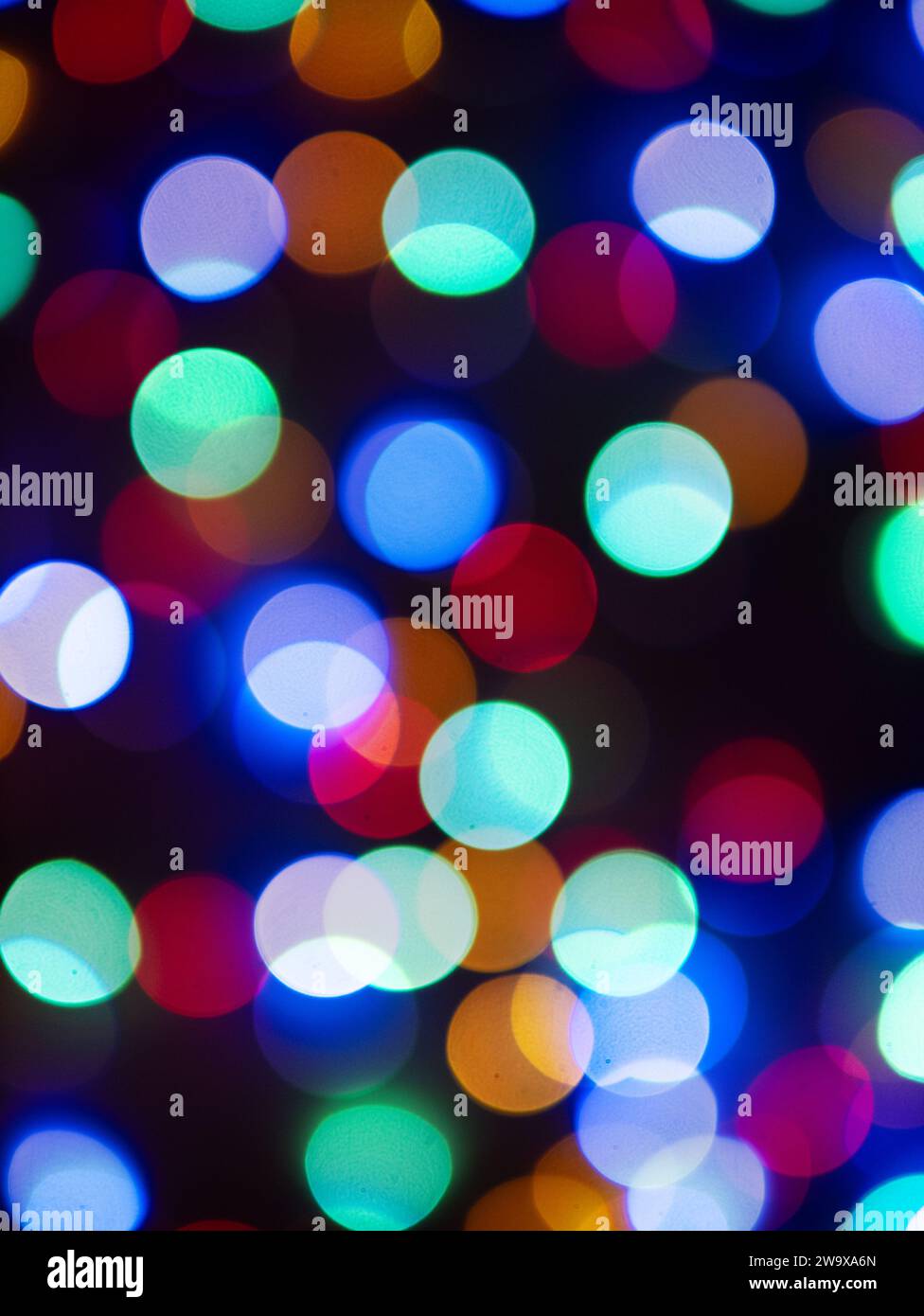 fond abstrait avec des cercles clairs colorés blurés sur fond sombre Banque D'Images
