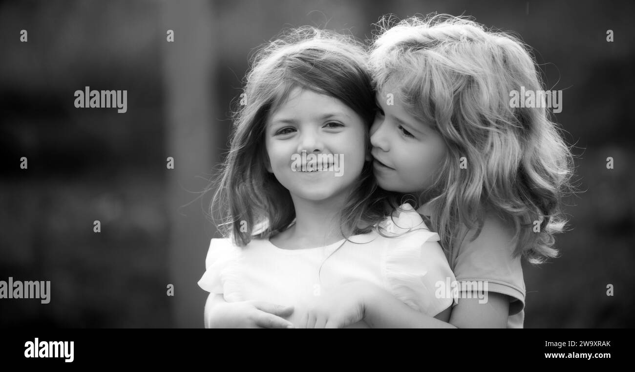 Petit garçon et fille meilleurs amis qui s'embrasse. Les enfants s'embrasser avec amour au parc d'été. Joyeux couple d'enfants amoureux à l'extérieur le jour de l'été, peu Banque D'Images