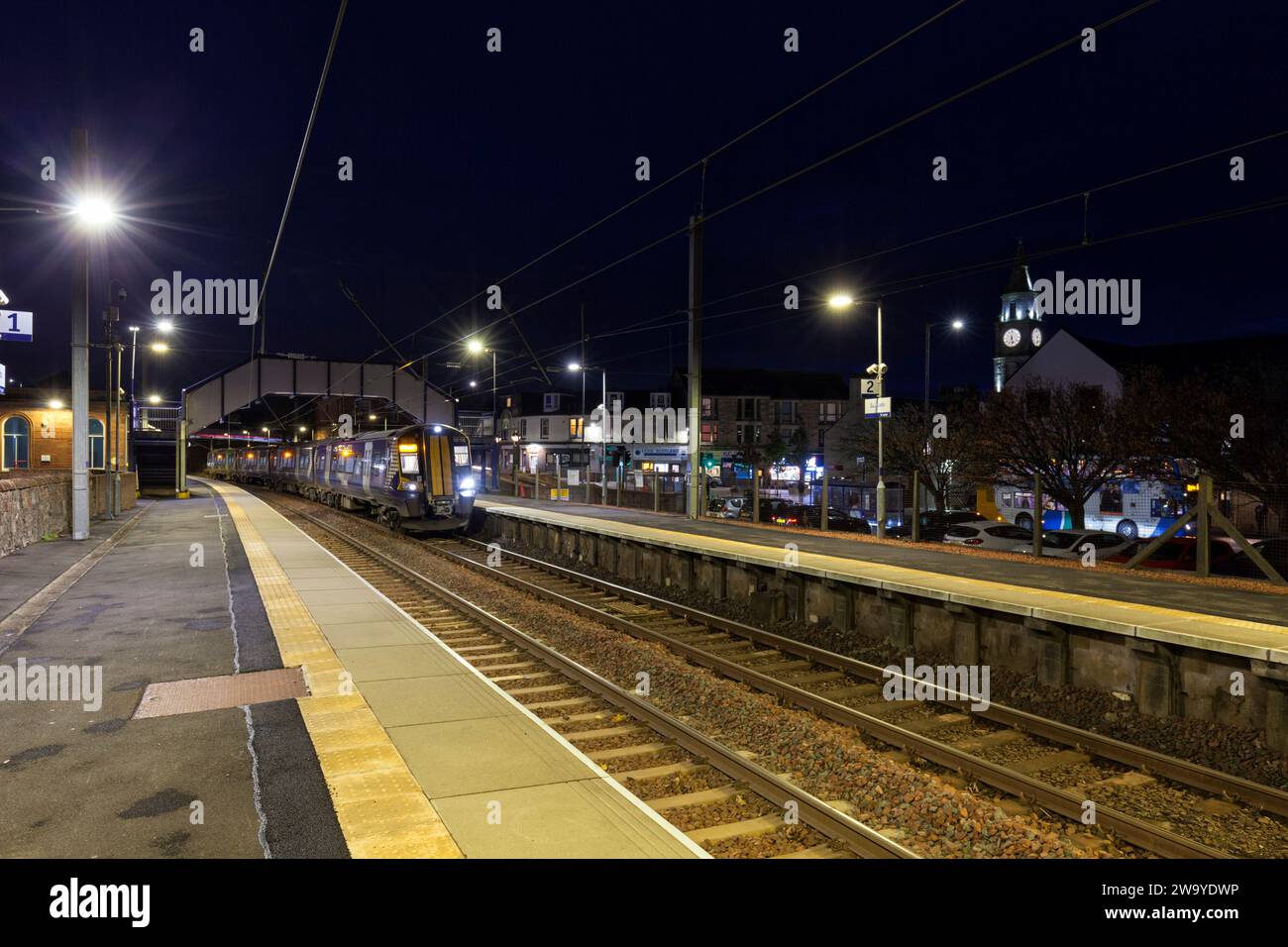 ScotRail Siemens Class 380 train électrique 380116 appelant à la gare de Saltcoates (Ayrshire), Écosse, Royaume-Uni la nuit. Banque D'Images