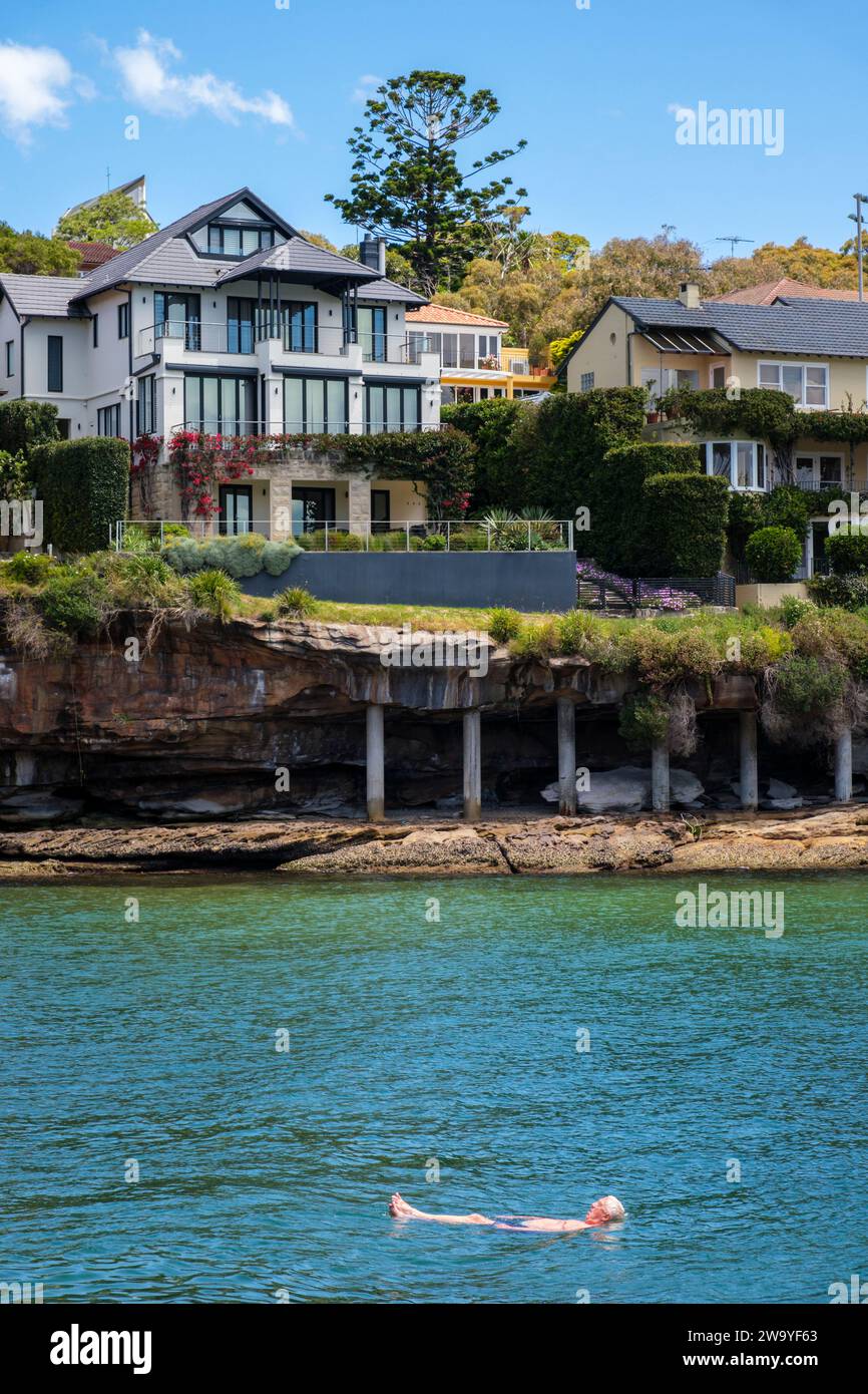Homme nageant à Parsley Bay, Vaucluse - l'une des banlieues les plus chères de Sydney Banque D'Images