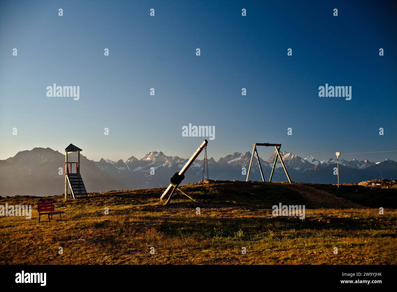 un playgrond pour enfants dans les alpes / montagnes avec le panorama des alpes dans le backround . Ein Spielplatz mit Alpenpanorama im hintergrund Banque D'Images