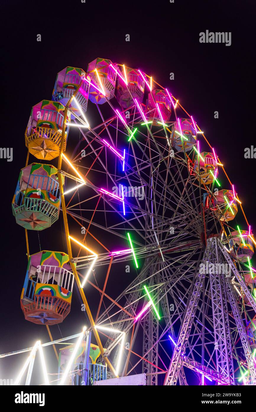 joyeux go ronde swing la nuit avec la lumière colorée au terrain de foire de la ville sous un angle différent Banque D'Images