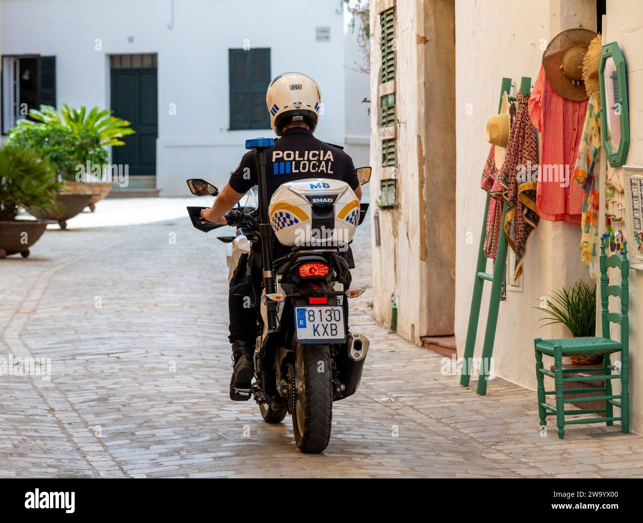 Policia local sur une moto à travers une ruelle à Ciutadella Menorca Minorque Espagne Banque D'Images