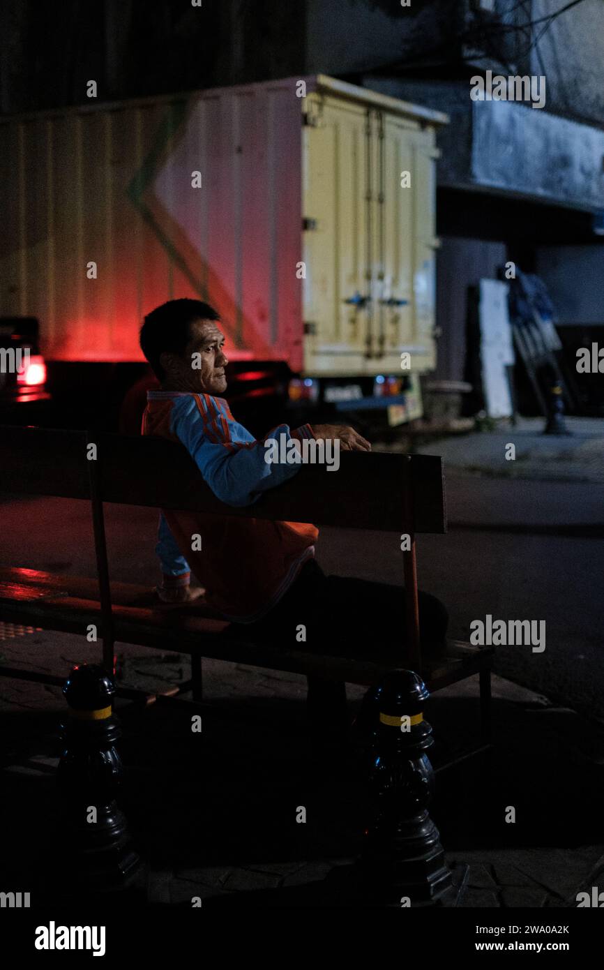 Jakarta, Indonésie - octobre 4 2023 : les lumières nocturnes illuminent l'homme assis Banque D'Images