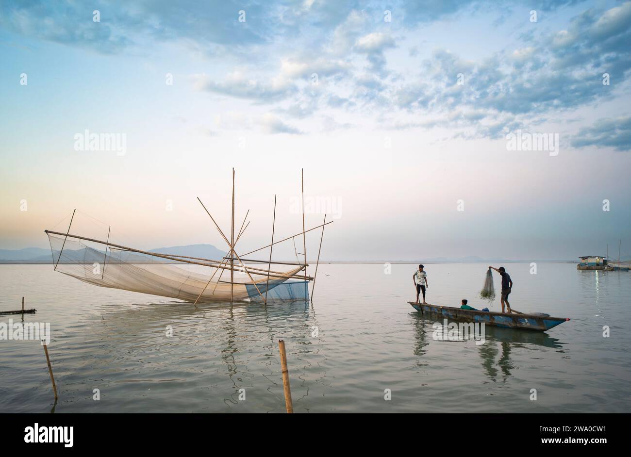 Guwahati, Assam, Inde. 31 décembre 2023. Les pêcheurs préparent leur filet de pêche sur la rive de la rivière Brahmapoutre au coucher du soleil, à Guwahati, Assam, Inde, le 31 décembre 2023. Crédit : David Talukdar/Alamy Live News Banque D'Images