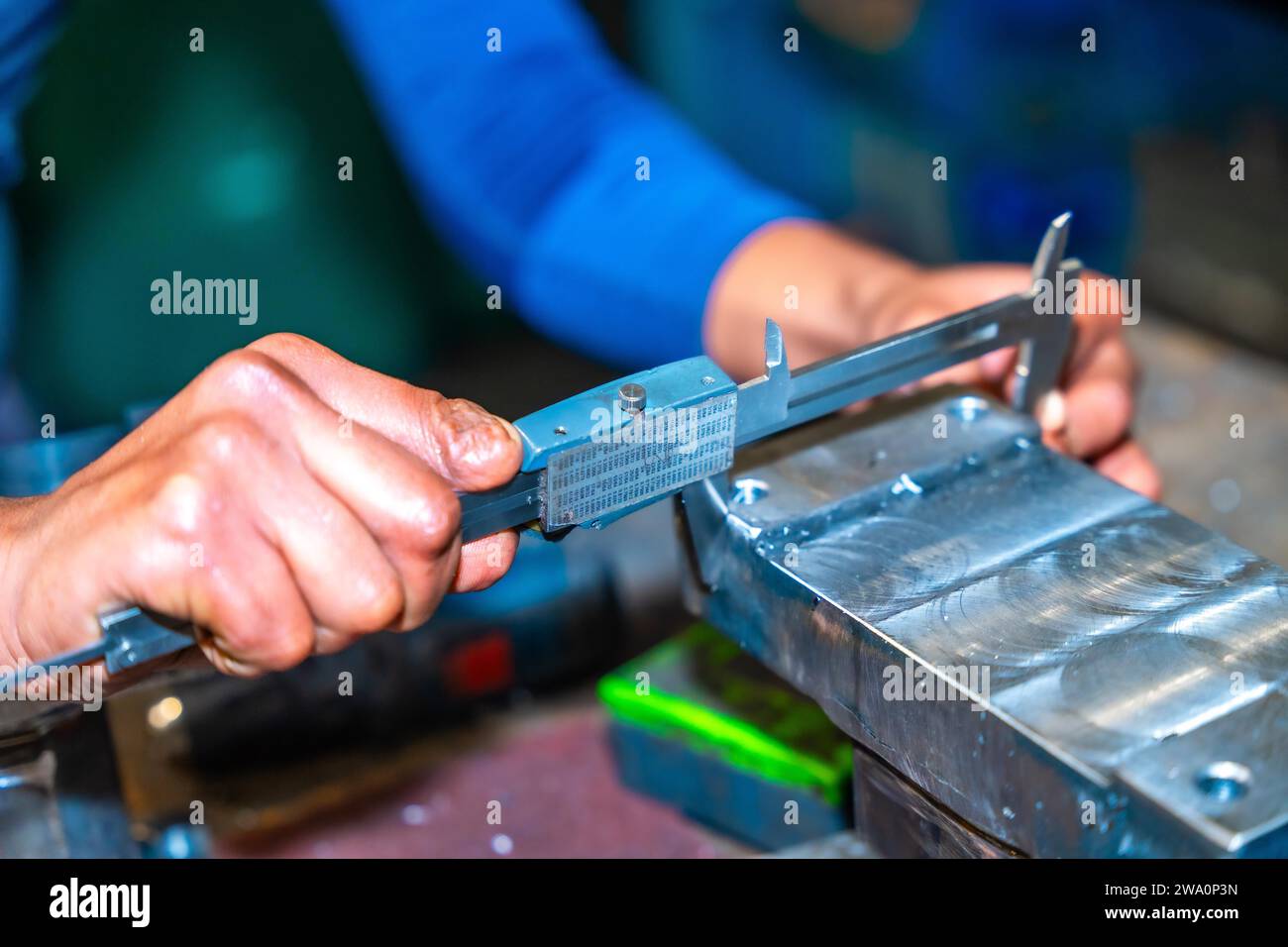 Opérateur avec un doigt coupé travaillant dans une entreprise avec fraises dans un atelier de commande numérique, haute technologie grâce à un centre d'usinage CNC. Banque D'Images