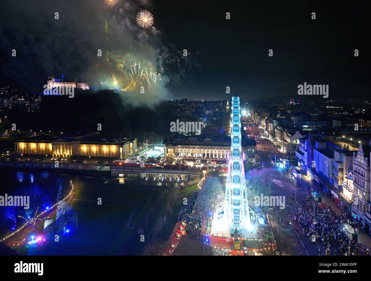 Édimbourg, Écosse, Royaume-Uni. 1 janvier 2024. Des feux d'artifice éclatent sur le château d'Édimbourg à minuit pour saluer le début de l'année 2024. Célébrant son 30e anniversaire, la Hogmanay Street Party et ses attractions battent toujours autour de Princes Street et de ses jardins, avec le groupe pop Pulp en tête d'affiche au kiosque Ross pour accueillir la nouvelle année. Photographié depuis le sommet du monument Walter Scott. Crédit : Craig Brown/Alamy Live News Banque D'Images