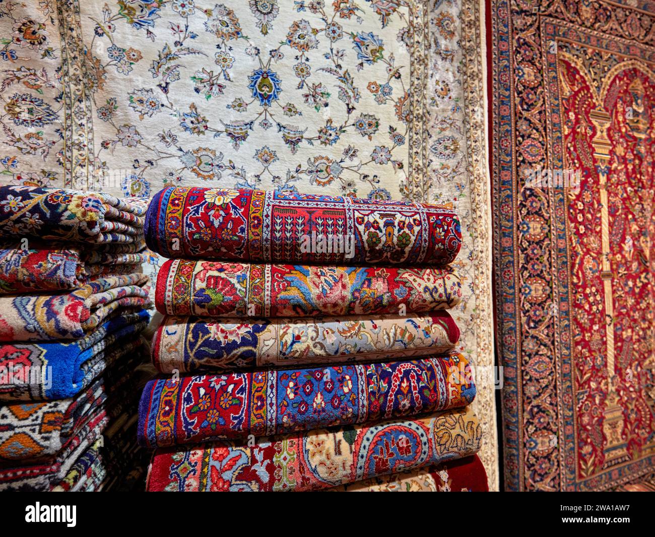 Sélection colorée de tapis persans faits à la main dans une boutique de l'Aminoddole Caravanserai, structure historique dans le Grand Bazar de Kashan, Iran. Banque D'Images