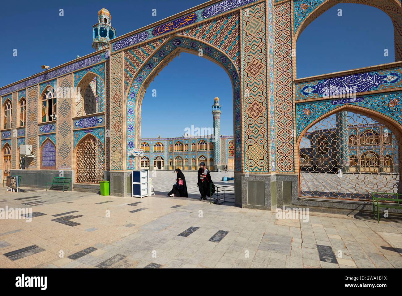 Les femmes marchent à travers une arche dans le sanctuaire Emamzade Mohammed Helal bin Ali. Aran o Bidgol, Iran. Banque D'Images