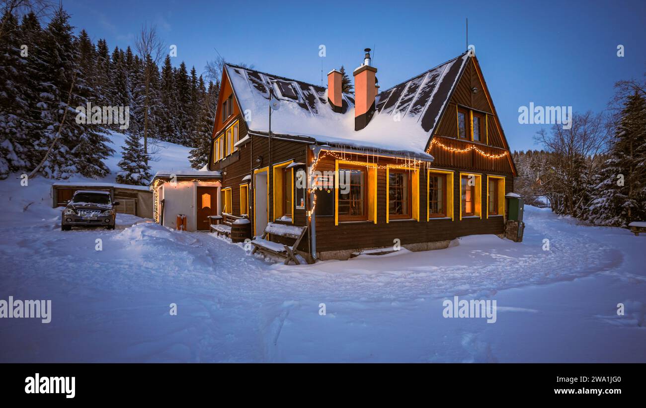 Cabine d'hiver magique couverte de neige blanche et décorée de lumières de Noël. Ambiance fantastique sur les montagnes de Bohême. Banque D'Images