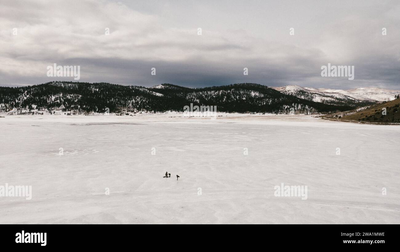Drone vue du lac gelé avec des pêcheurs de glace sur elle et des collines autour Banque D'Images